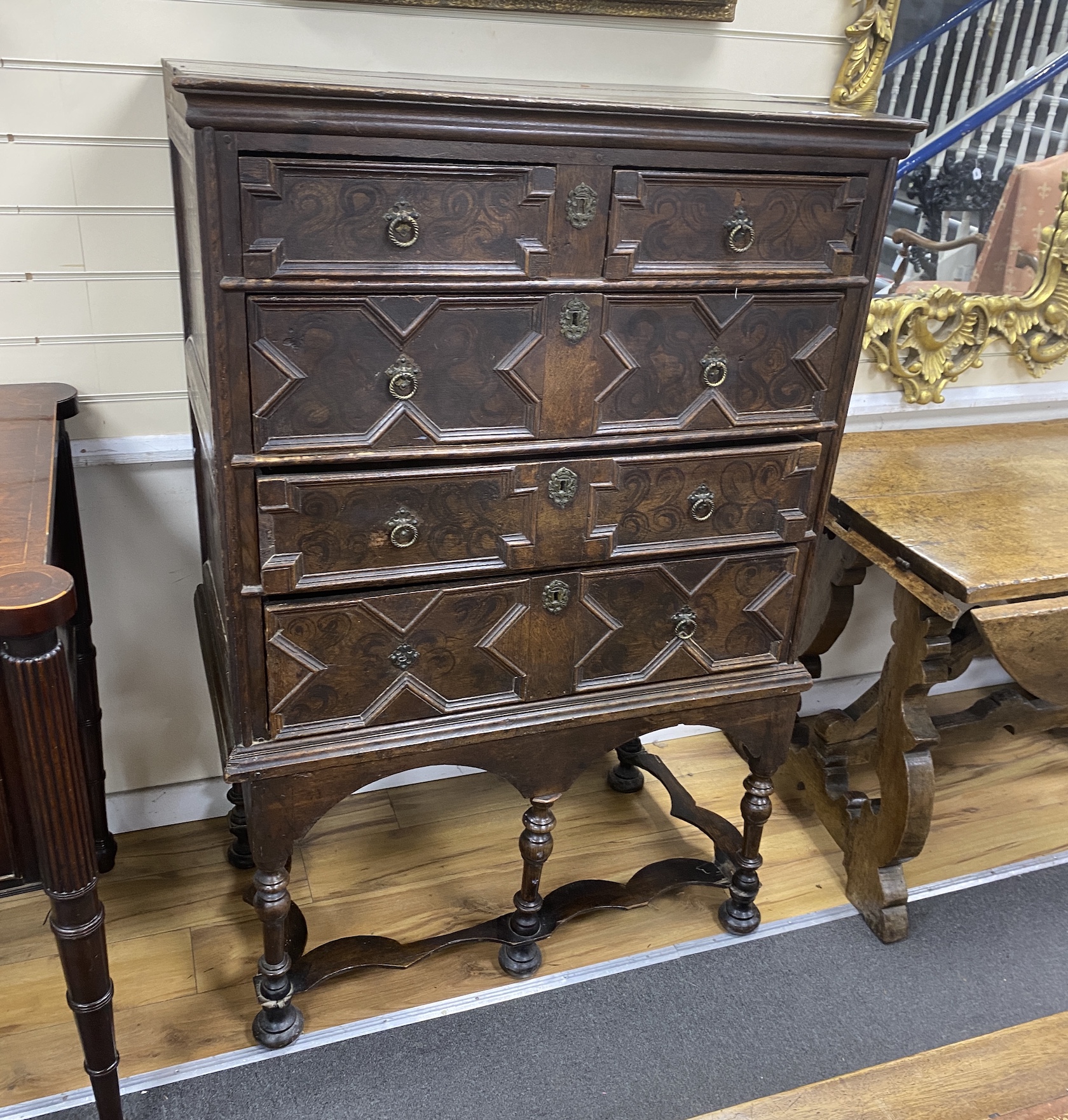 An 18th century oak chest on stand, the drawers with painted simulated grain, width 97cm, depth 56cm, height 147cm